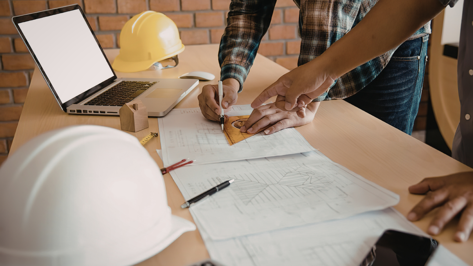 Construction company owner standing at a job site with crew and equipment, considering selling his business